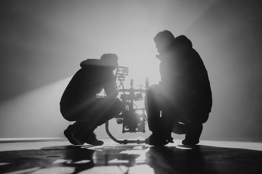 grayscale photography of two crouching men